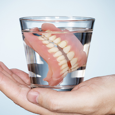 Full denture in a glass of water