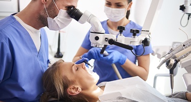 Dentist examining patient under a microscope