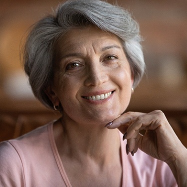 Older woman with dental implants in Guilderland smiling