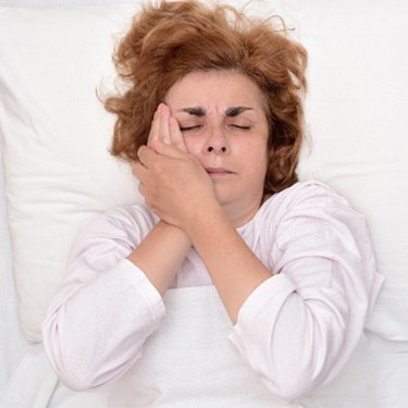 woman with toothache in bed  