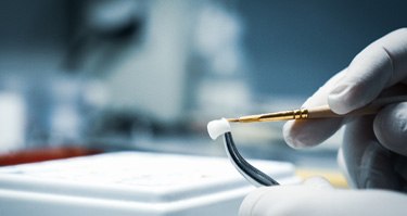 A lab worker crafting a dental crown