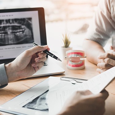 a dentist consulting with a patient across a table