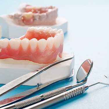 full dentures sitting atop a plaster mold