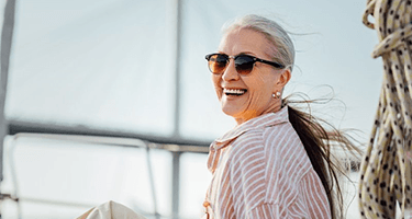 a mature woman smiling with All on 4 Dentures