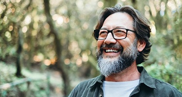 a man smiling during a hike in the woods