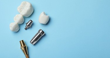 The parts of dental implants and bridges against a blue background