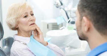 senior woman in pain talking to her emergency dentist in Guilderland 