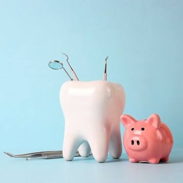 a tooth and dental tools next to a piggy bank