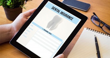 a person holding a tablet for dental insurance