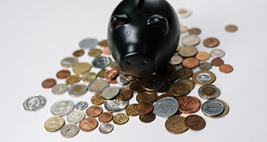 Black piggy bank and coins