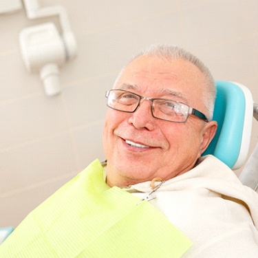 Senior man visiting dentist with implant dentures in Guilderland, NY