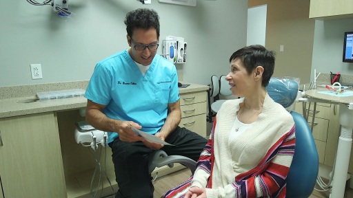 Doctor Oshins showing a photo to a dental patient