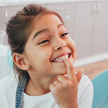 Child pointing to tooth with filling