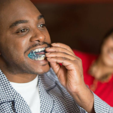 Man placing oral appliance for sleep apnea