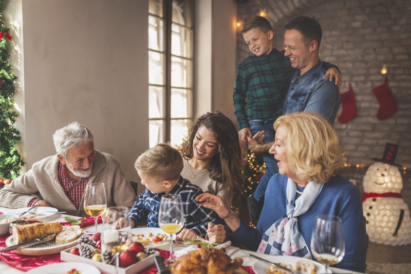 Family practicing holiday oral health tips at the dinner table.