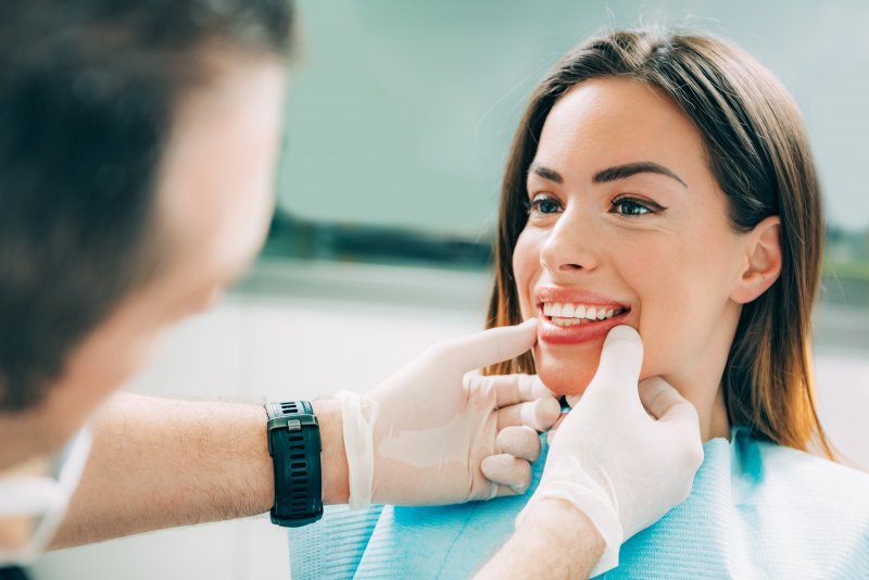Cosmetic dentist looking at patient's smile