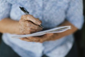 mature woman writing on notepad