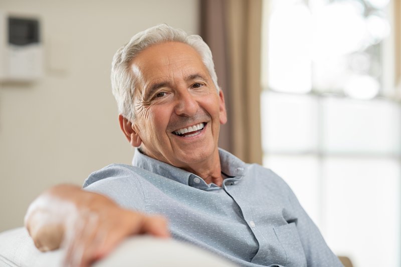 man smiling after transitioning from dentures to dental implants