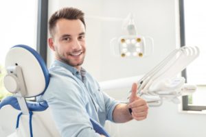 man giving a thumbs up at his dental checkup and cleaning 