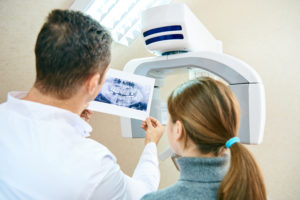 A dentist show dental X-ray to female patient