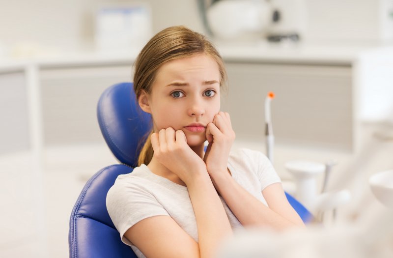 A young woman anxious about getting dental crowns